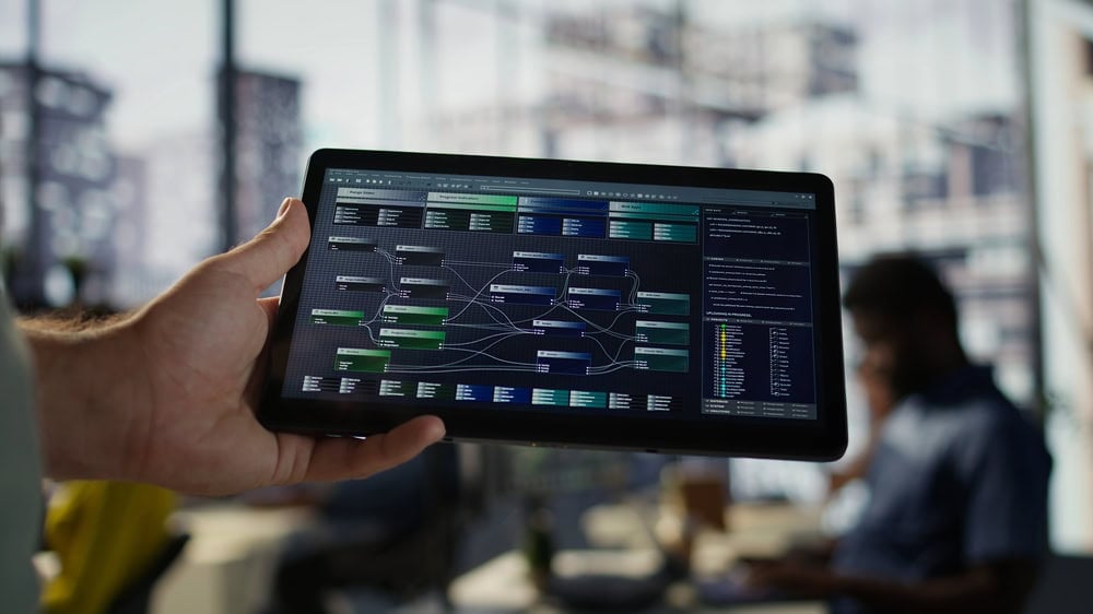 A person holds a tablet displaying a complex flowchart about cloud computing service models, with connected nodes and text…