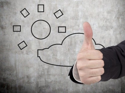 A person in a suit gives a thumbs-up in front of a wall with a simple drawing of a sun and cloud.